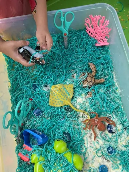 Another example of our sensory bins, this one with an ocean theme, allows kids to explore different textures and small toys in a contained, creative play area.