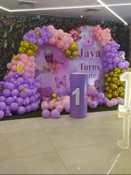 A butterfly-themed first birthday with a purple, pink, and gold color scheme. This lawn decoration features a large backdrop, balloon columns, and a light-up number '1'.