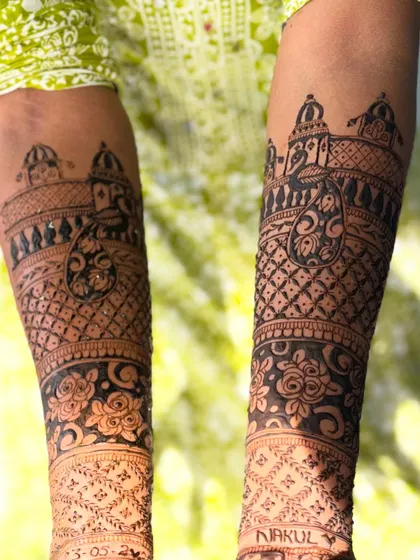 A closer look at the forearm details of a bridal design, featuring architectural dome (gopuram) and paisley motifs.