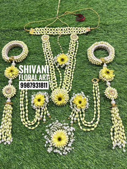 A beautiful bridal jewellery set for Haldi, featuring yellow flowers and Tagar buds. The set includes a choker, a long necklace, and heavy kalire.