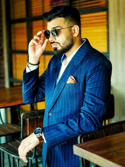 Our navy blue pinstripe suit, styled for a modern business look. The fit is sharp and commanding, a testament to the power of a perfectly tailored garment.