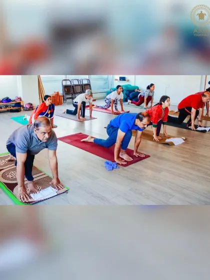 A group of senior students moves through a gentle lunge sequence, working on flexibility and strength in a supportive and non-competitive atmosphere.