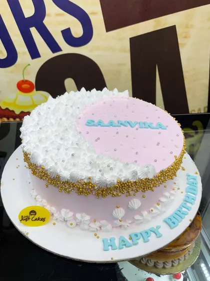 A 2kg moon-themed cake with a pink and white design, accented with gold and silver sprinkles.