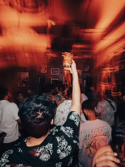 Cheers to the weekend! A shot from the crowd, drink in hand, enjoying the party.