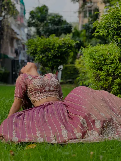 Another artistic pose in the dusty rose lehenga, showcasing the flow and detail of the skirt.