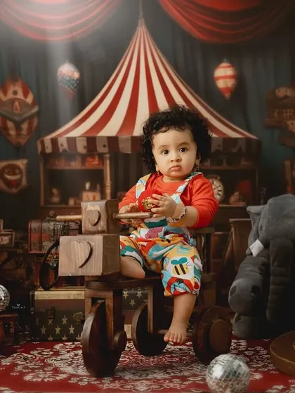 Welcome to the circus. This elaborate setup features a toddler as the star of the show, surrounded by classic circus props and a vintage aesthetic.