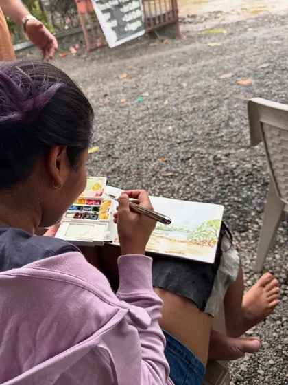 A view from behind as I work on a landscape sketch. My portable watercolour kit is my constant companion on my travels.