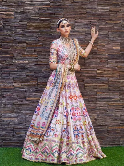 A vibrant, multi-colored lehenga that is perfect for a mehendi ceremony. The makeup is kept fresh and radiant to balance the colorful outfit, with a focus on a flawless base and bright eyes.