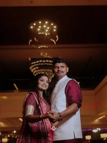 A wide-angle shot of a couple standing in a grand, beautifully lit hall.