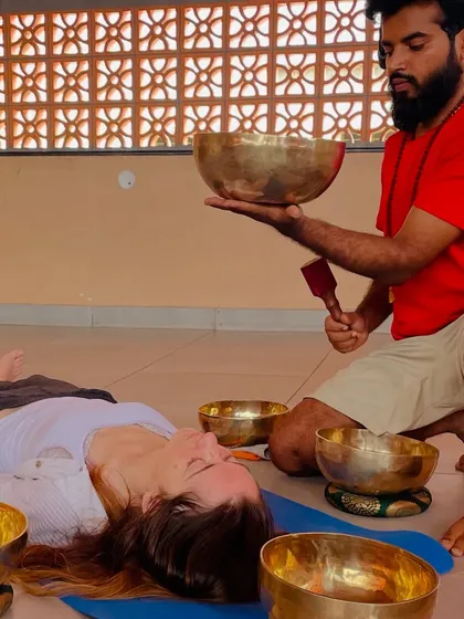 Bringing the healing vibrations of a singing bowl close to a participant.