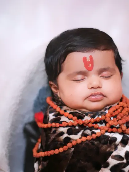 A portrait showing the baby with the mini trishul prop in the 'Little Shiva' setup.