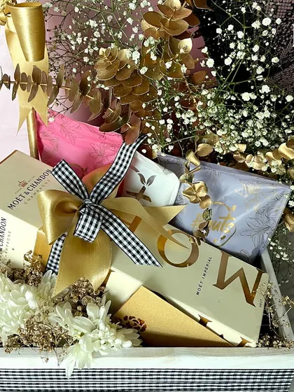 A close-up of the black, white, and gold birthday hamper, showing the Moët & Chandon box and other luxury items. This highlights the premium brands I work with to create truly indulgent gifts.