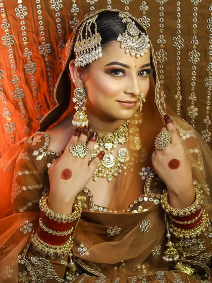 This portrait shows the full set of jewelry, including the large rings and bangles, which are integral to the bridal look.