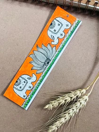 A hand-painted bookmark featuring elephants and a lotus in the Madhubani style. It's a small piece of traditional art to accompany you on your reading journey.