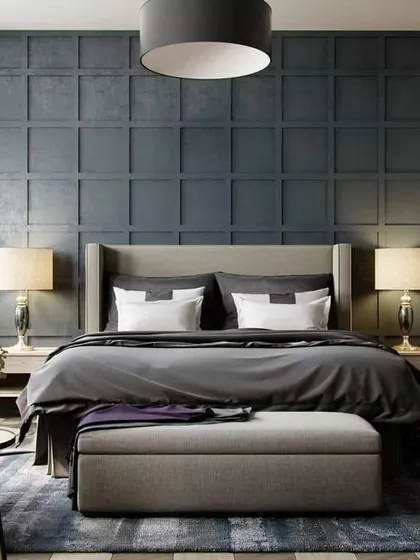 A moody and sophisticated bedroom with a dark, paneled accent wall. The high wingback bed and symmetrical bedside lamps create a formal and balanced look.