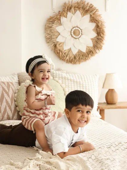The bond between siblings is a story in itself. I love capturing these moments of pure, unfiltered fun, like this big brother and his baby sister sharing a laugh during their cozy studio session.