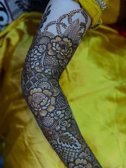 A close-up of the forearm, showing the detailed shading and line work in this signature floral piece.