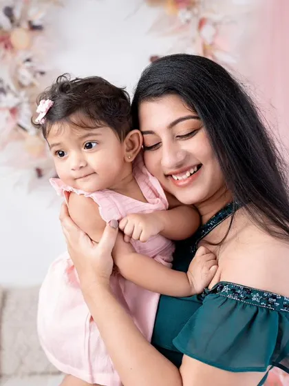 A mother and her baby girl, both looking so sweet and serene. The soft pink and green colors create a gentle and feminine mood.