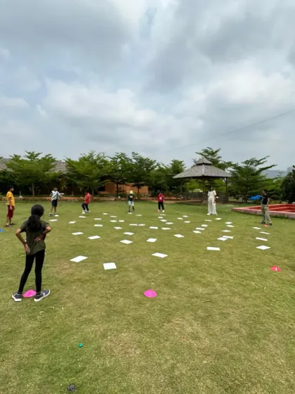 Kids engaged in a dynamic team-building activity on a grassy field. These games are designed to foster communication, collaboration, and problem-solving skills in a fun way.