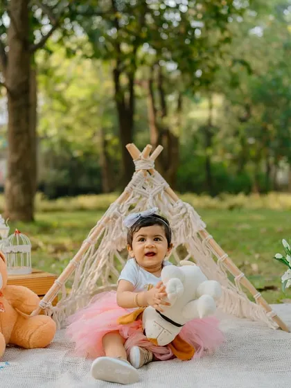A first birthday picnic in the park! This outdoor setup with a teepee and teddy bear is perfect for a nature-loving little one.