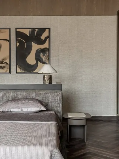 The bed in the master suite at Aikaa. The low, upholstered headboard and dark wood floors create a grounded, stable feeling, perfect for a restful night's sleep.