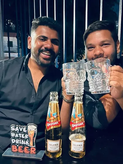 The champions celebrating their win. Two friends proudly show off their skull mugs and enjoy a well-deserved beer after a tough tournament.