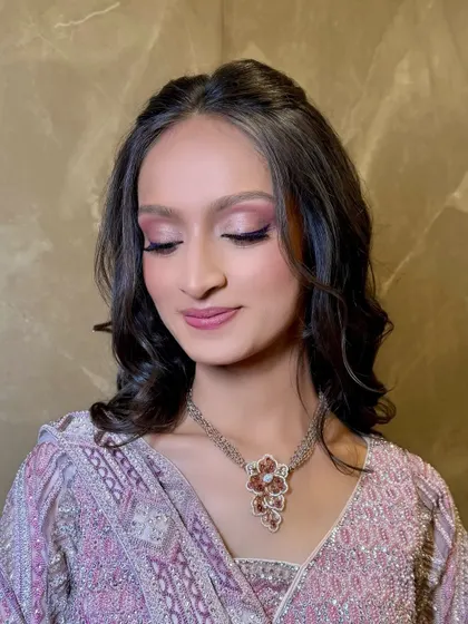 A close-up on the eye makeup, showing the soft pink and purple tones that complement her outfit.