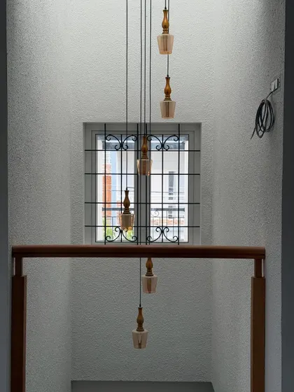 If you can’t decide between symmetry and surprise, do both. A cluster of hanging pendant lights creates a beautiful, cascading effect in this stairwell.