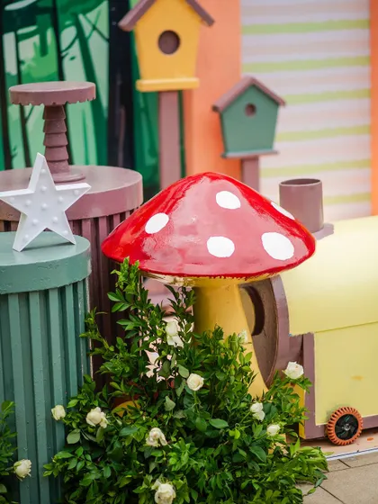 A whimsical red-and-white mushroom prop adds a touch of fairytale magic to the jungle theme. I love mixing elements to create a unique and imaginative world.