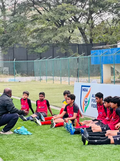 Building strong professional bonds. A coach provides tactical advice and encouragement to his team during a break in play.