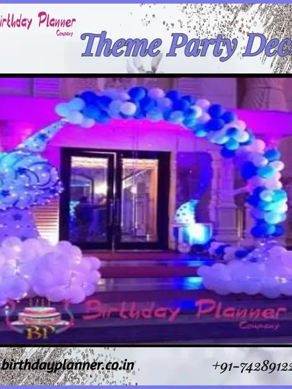 This entrance features a blue and white balloon arch that appears to float on clouds of white balloons at the base. The purple uplighting adds a magical, dreamy quality to the party's entryway.