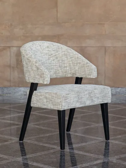 The 'Adira Chair', named for the Sanskrit word for "strong." Handcrafted by local artisans from solid oak, its sleek yet sturdy construction, gently curved back, and cushioned seat offer a statement in sustainable design and comfort.