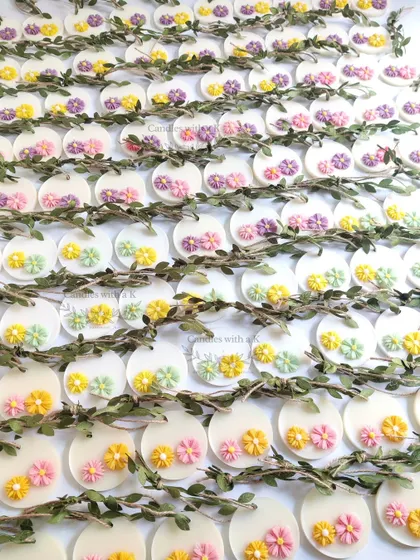 A large order of 100 personalized soy wax sachets with colorful wax flowers, crafted as wedding return gifts for Zeba in Mumbai.