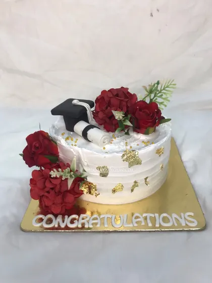 Because every milestone deserves a celebration. This elegant cake was for a graduation, featuring a fondant graduation cap, a diploma, and beautiful red flowers.
