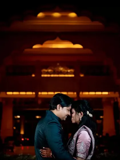 A romantic silhouette of a couple at their reception, with the grand architecture of the venue lit up behind them.