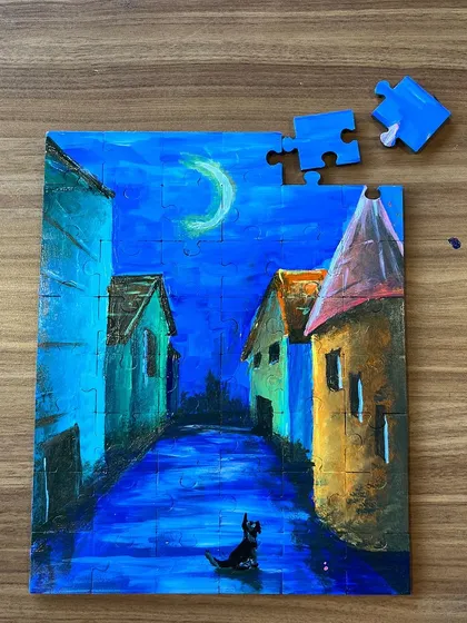 A finished puzzle painting of a whimsical street scene. Once you're done painting, you have a fun puzzle to solve.