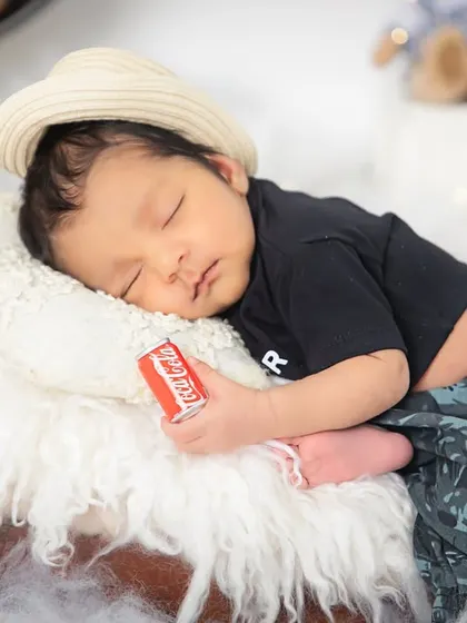A close-up of our little dreamer, holding a tiny coke can prop. It's these small, playful details that make each themed shoot special and fun.