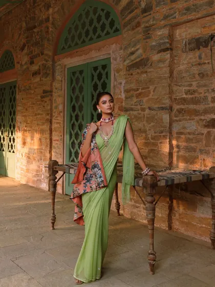 A serene yet opulent look from a heritage jewellery campaign. I styled a lime green saree with a floral cape and a stunning ruby choker and necklace set, creating a beautiful contrast against the rustic stone architecture.