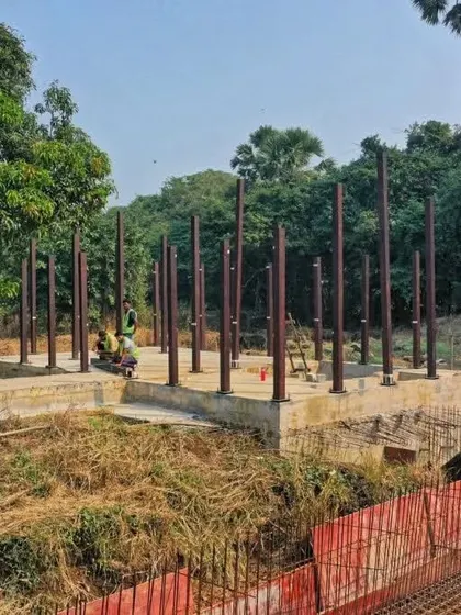 The steel columns are set into the plinth, ready to receive the timber structure for the Awas House. The design carefully preserves the existing mango tree on the site.