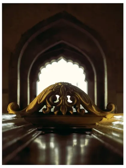 A beautifully composed shot from inside Safdarjung's Tomb, looking out through a series of arches. The carved marble cenotaph is perfectly framed, creating a sense of depth and history.