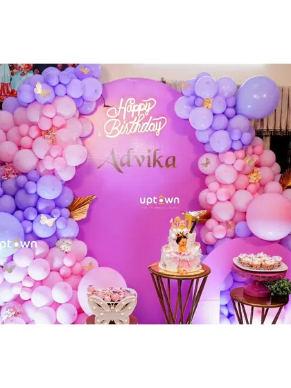 A simple yet elegant butterfly theme with pink and purple balloons against a large purple backdrop.