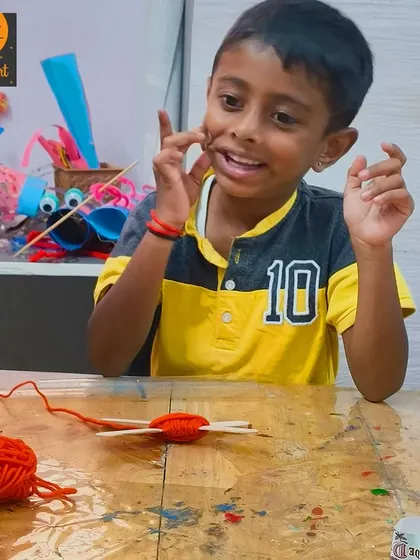 The joy of figuring it out! This student is fully engaged in his yarn craft, a great activity for problem-solving and creative thinking.