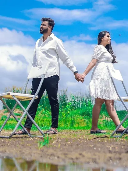 An artistic outdoor shot for a pregnancy announcement, with the couple holding hands against a beautiful sky, ready for their new chapter.
