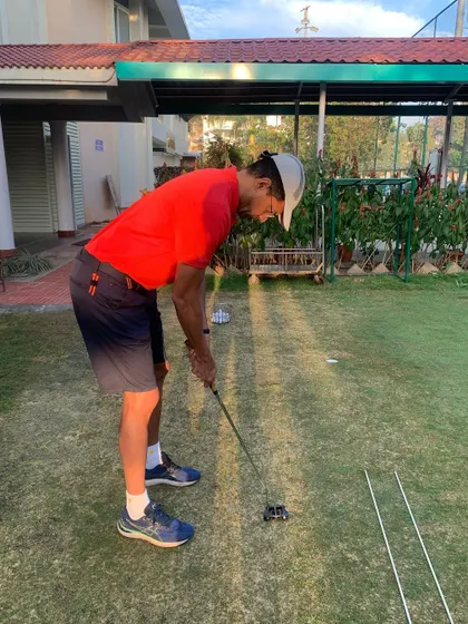A new student practices his putting posture. We focus on getting the fundamentals right, like eye position over the ball and a relaxed setup.