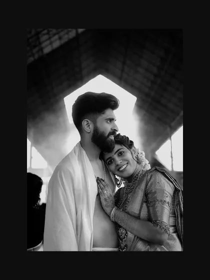 A tender black and white portrait of the bride resting her head on the groom's shoulder.