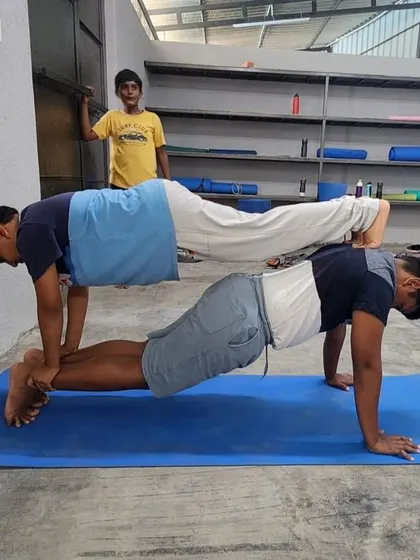 A slightly different configuration of the double plank, showing how we adapt poses for different body types and strengths.
