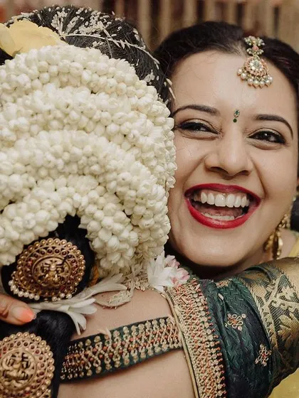 A moment of pure joy and friendship. This candid shot of a guest giving the bride a big hug from behind, both with huge smiles, captures the celebratory and happy spirit of the day.