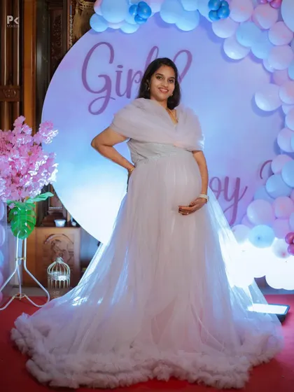 Another pose from the baby shower photoshoot, showcasing the elegant gown and festive decor. I can capture a variety of posed and candid shots during your event.