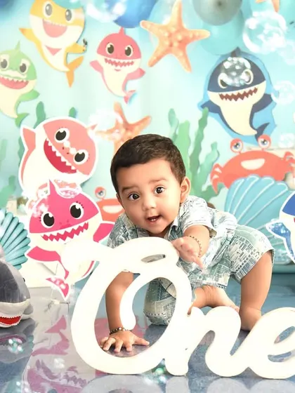 Crawling into his first year with a splash! This Baby Shark themed first birthday shoot is full of color and fun, marking the big "One" in a playful way.