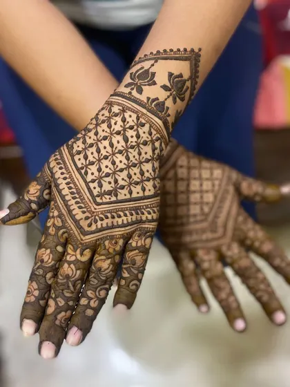 A striking design that combines a geometric grid pattern with a lotus cuff. The contrast between the sharp lines and floral elements is beautiful.